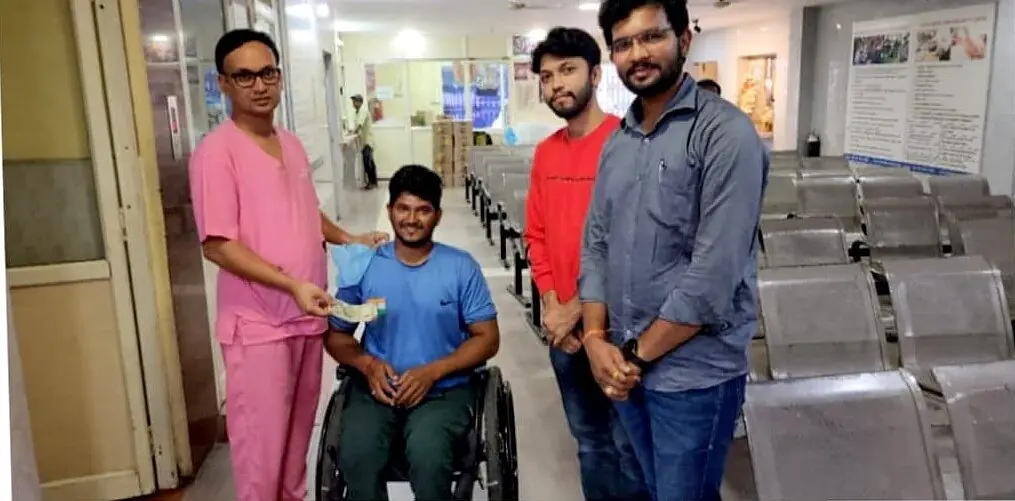 Dr. Sridhar presenting support to a para-badminton player in a wheelchair