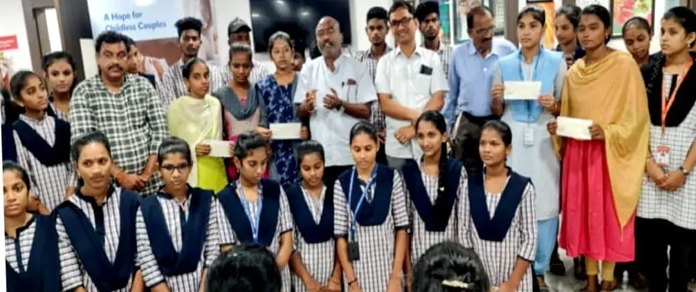 Students holding award cheques with Dr. Sridhar at the Sikkolu Excellence Awards