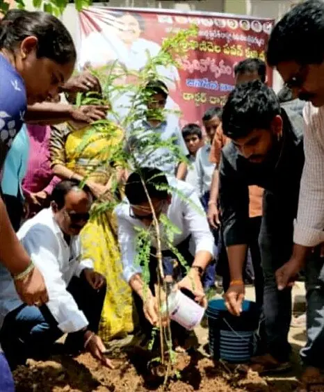 Dr. Sridhar planting a sapling with students and teachers