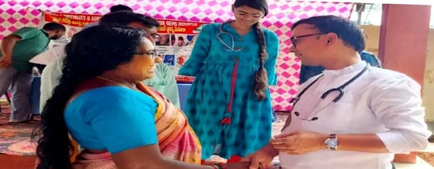 Dr. Sridhar with a stethoscope, listening to a woman at a village medical camp